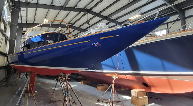 Slide: The Image of 2023 C.W. Hood 32 Daysailer in a boatyard, blue hull, on stands. - 3