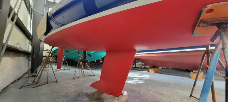 Slide: The Image of 2023 C.W. Hood 32 Daysailer in a workshop, showcasing its red hull and keel. - 5