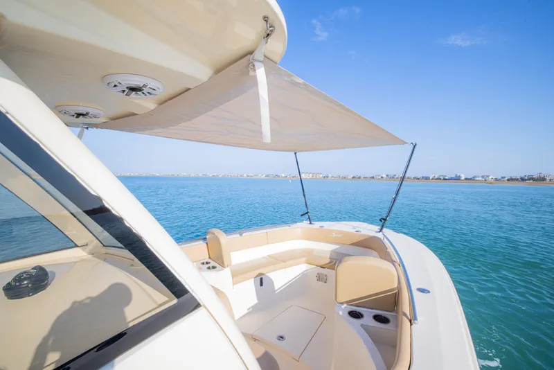 Slide: The Image of 2021 Scout 277 LXF boat with sunshade on calm blue water. - 14