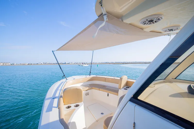 Slide: The Image of 2021 Scout 277 LXF boat with sunshade on calm blue water. - 15