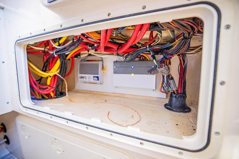 Slide: The Image of 2021 Scout 277 LXF boat wiring compartment with organized cables and electrical components. - 18