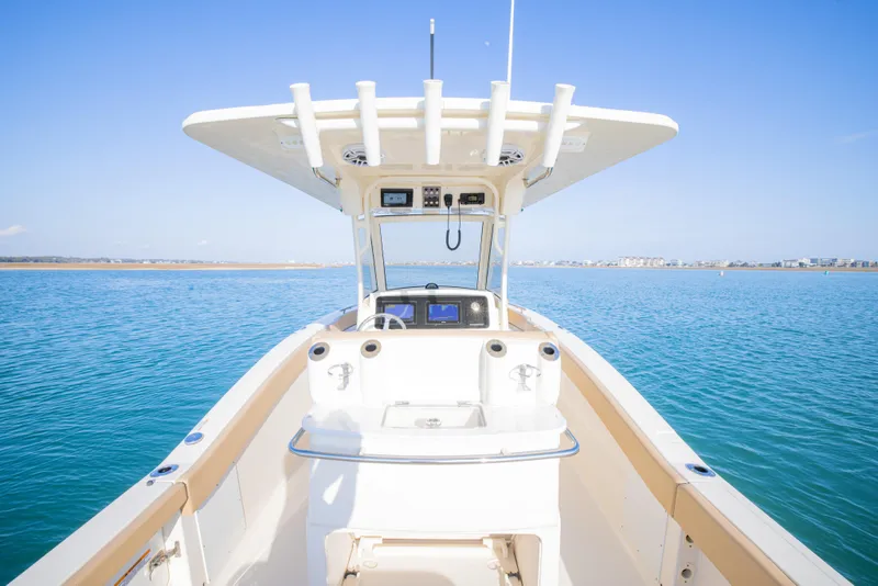 Slide: The Image of 2021 Scout 277 LXF boat on calm blue water, featuring a sleek design and modern console. - 19