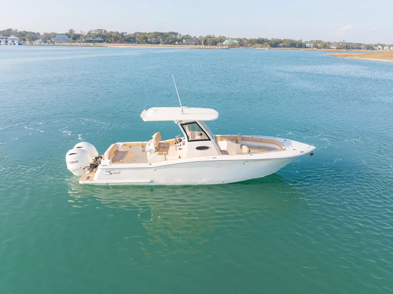 Slide: The Image of 2021 Scout 277 LXF boat on calm blue water, side view. - 2