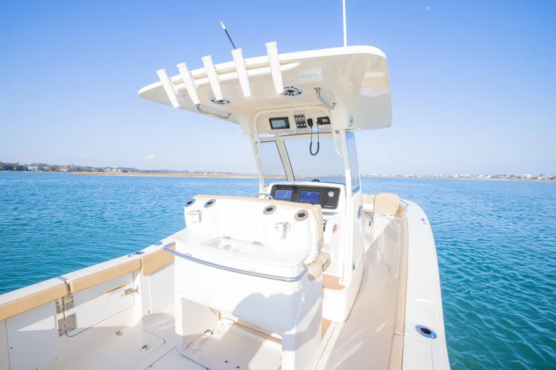 Slide: The Image of 2021 Scout 277 LXF boat on clear blue water, featuring modern helm and seating. - 20