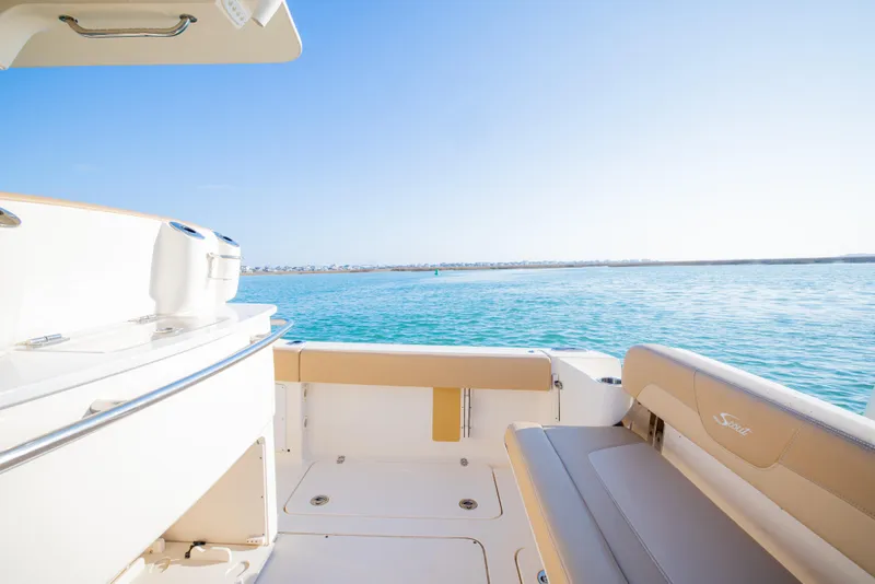 Slide: The Image of 2021 Scout 277 LXF boat interior with ocean view, featuring sleek seating and clear blue water. - 27
