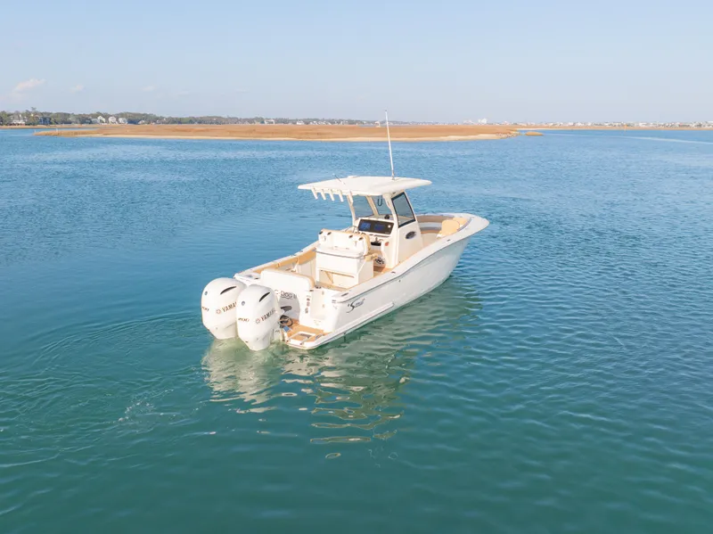 Slide: The Image of 2021 Scout 277 LXF boat cruising on calm blue water. - 3