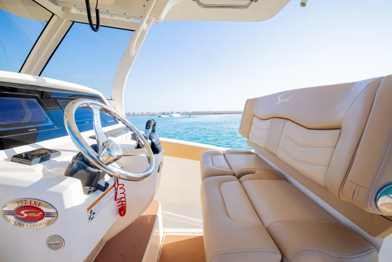 Slide: The Image of 2021 Scout 277 LXF boat interior with steering wheel and beige seating. - 32