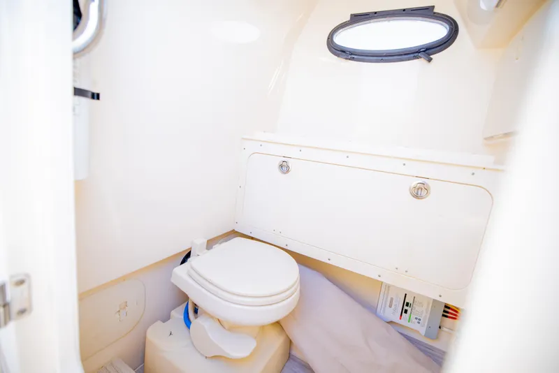 Slide: The Image of 2021 Scout 277 LXF boat interior with compact marine toilet and storage. - 33
