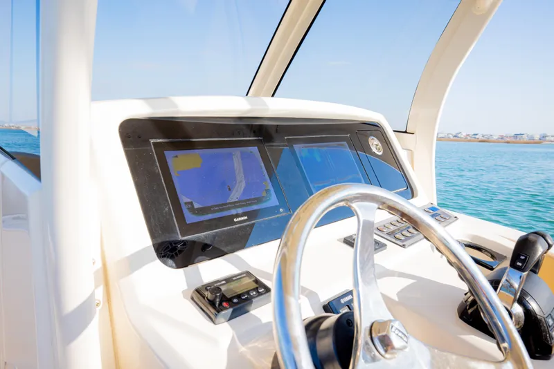 Slide: The Image of 2021 Scout 277 LXF boat dashboard with navigation screens and steering wheel. - 35