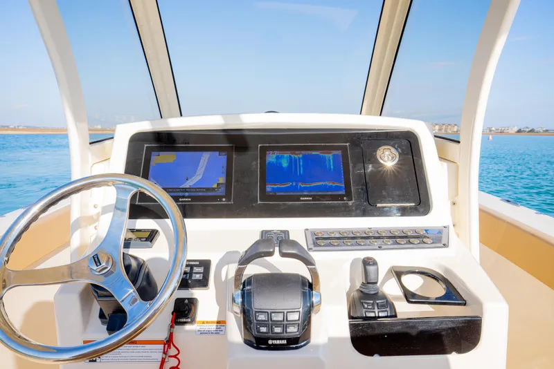 Slide: The Image of 2021 Scout 277 LXF boat dashboard with steering wheel and navigation screens. - 36