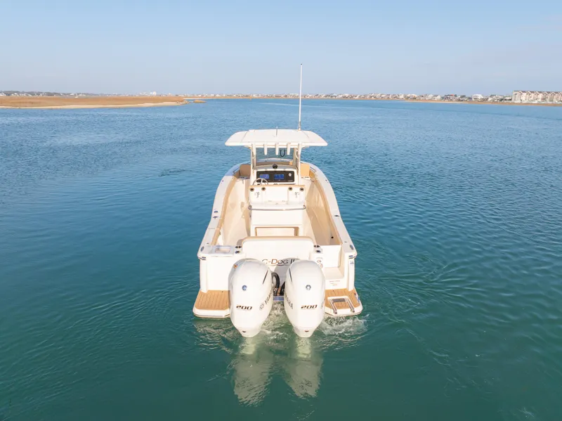 Slide: The Image of 2021 Scout 277 LXF boat with dual engines on calm water. - 4