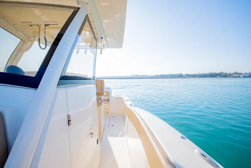 Slide: The Image of 2021 Scout 277 LXF boat cruising on clear blue water. - 40