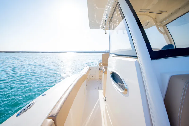 Slide: The Image of 2021 Scout 277 LXF boat cruising on clear blue water. - 41