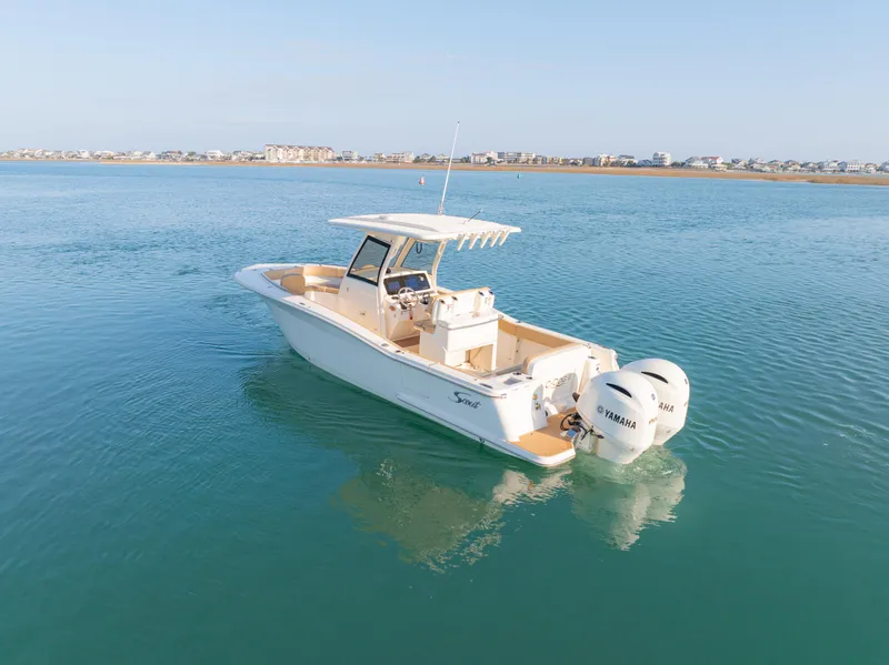 Slide: The Image of 2021 Scout 277 LXF boat on calm water with dual Yamaha engines. - 5