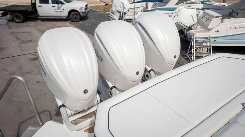 Slide: The Image of Three Yamaha outboard motors on a 2025 Cobalt R33 boat, parked near other boats. - 14