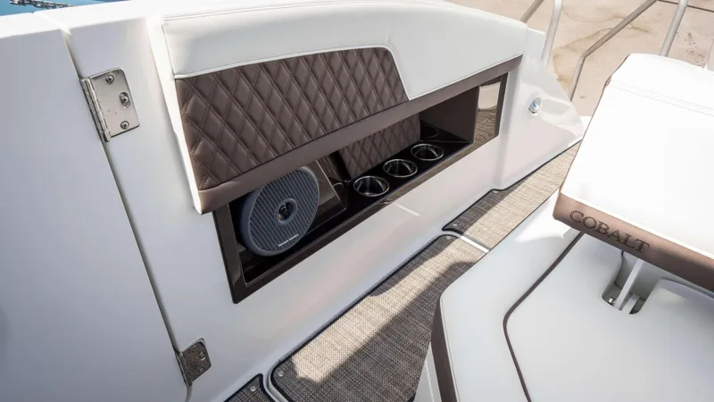 Slide: The Image of 2025 Cobalt R33 boat interior with cup holders and speaker, featuring elegant upholstery. - 17