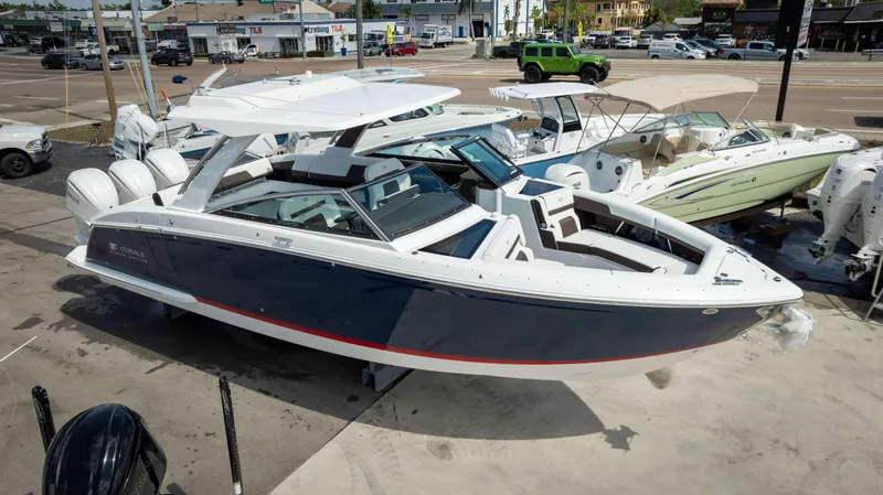 Slide: The Image of 2025 Cobalt R33 boat with sleek design, docked at a marina, surrounded by other boats. - 3