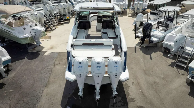 Slide: The Image of 2025 Cobalt R33 boat with triple outboard engines, displayed among other boats at a marina. - 9
