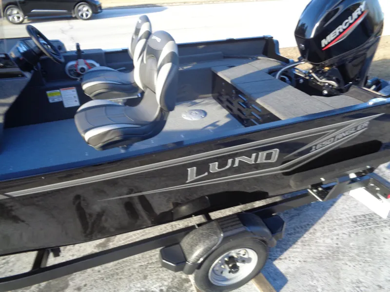 Slide: The Image of 2025 Lund 1650 Angler SS boat with Mercury engine, black exterior, and dual seats. - 2