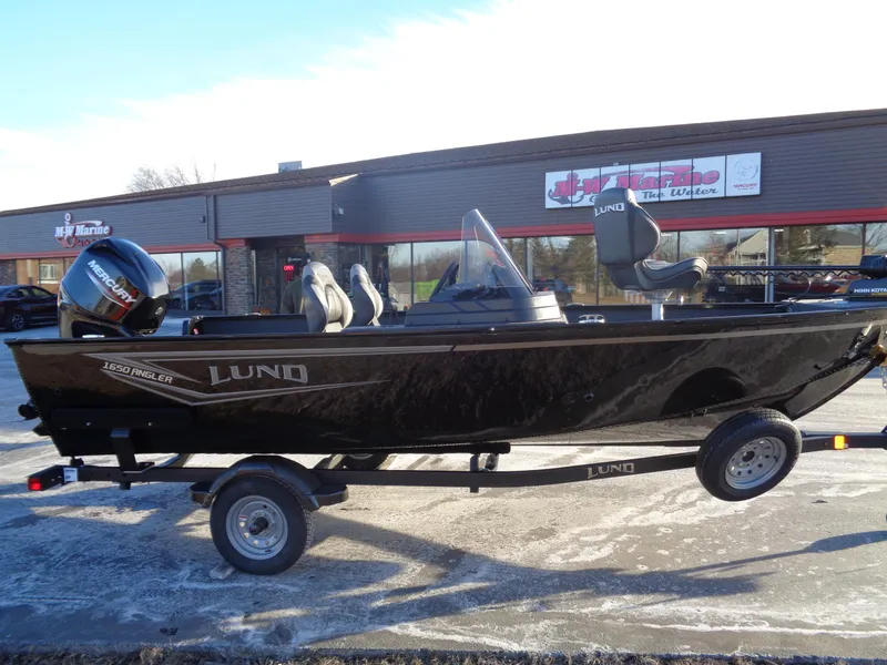 Slide: The Image of 2025 Lund 1650 Angler SS boat on trailer, parked outside a dealership. - 5