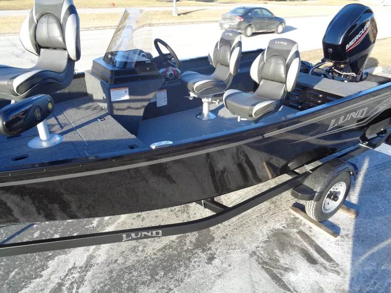 Slide: The Image of 2025 Lund 1650 Angler SS boat with seating and motor, parked on a trailer. - 7