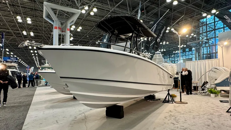 Slide: The Image of 2025 Edgewater 208CC Watchman boat displayed at an indoor exhibition. - 1