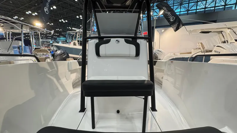 Slide: The Image of 2025 Edgewater 208CC Watchman boat interior at a boat show, showcasing seating and console. - 7
