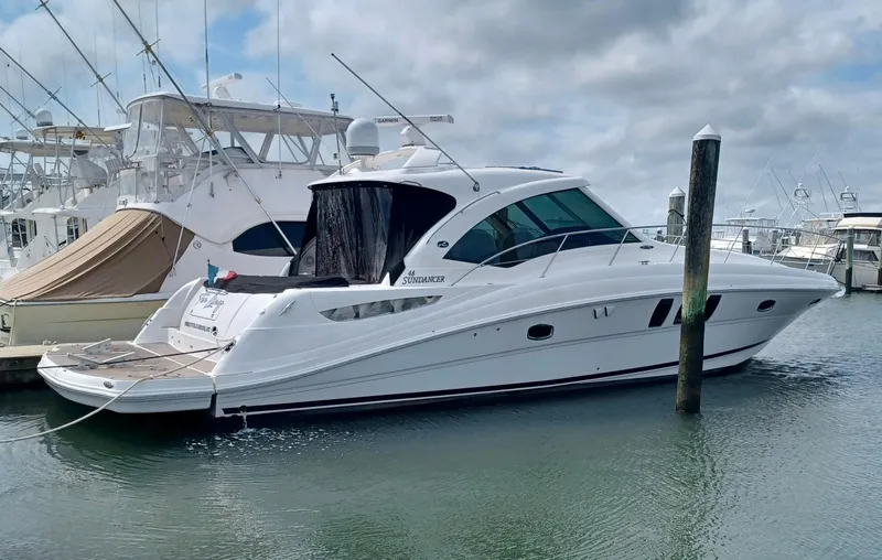The Image of 2006 Sea Ray 48 Sundancer yacht docked in a marina on a cloudy day. - 0