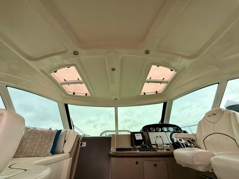 Slide: The Image of Luxurious 2006 Sea Ray 48 Sundancer interior with beige seating and wooden table. - 2