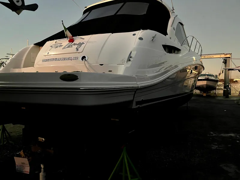 Slide: The Image of 2006 Sea Ray 48 Sundancer yacht on dry dock, rear view, with sleek white design. - 22