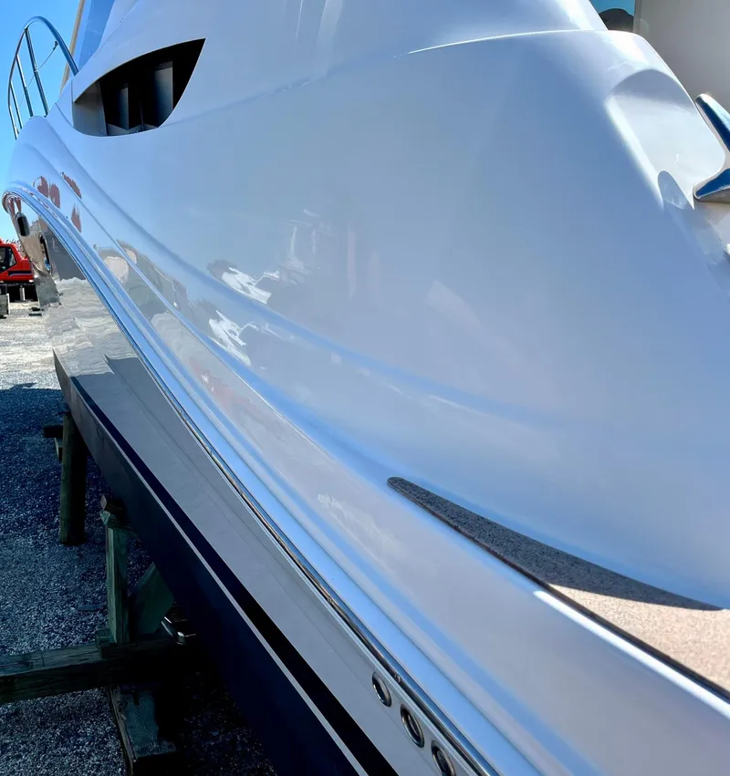 Slide: The Image of 2006 Sea Ray 48 Sundancer yacht, sleek white hull, docked on a sunny day. - 31