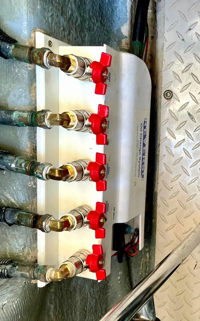 Slide: The Image of 2006 Sea Ray 48 Sundancer engine compartment with red valve controls and metal flooring. - 33