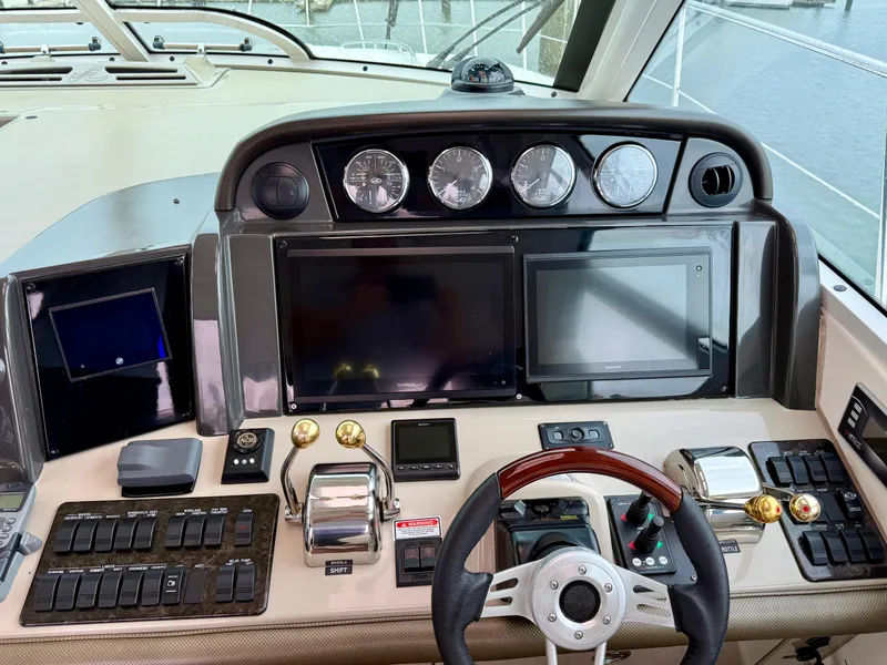 Slide: The Image of Helm of 2006 Sea Ray 48 Sundancer yacht with modern navigation controls and steering wheel. - 42