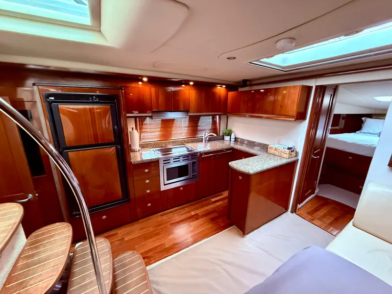 Slide: The Image of Luxurious interior of 2006 Sea Ray 48 Sundancer yacht with modern kitchen and wood finishes. - 7