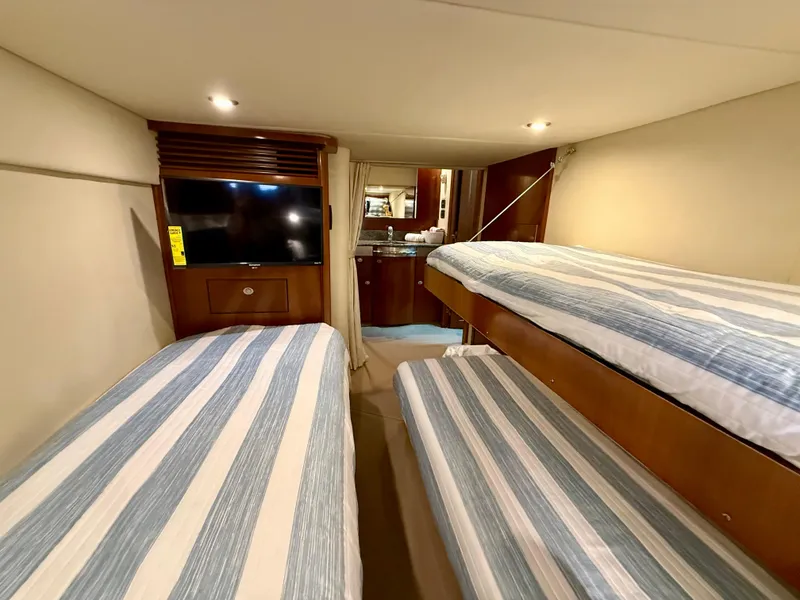 Slide: The Image of Interior cabin of 2006 Sea Ray 48 Sundancer with striped bedding and TV. - 8