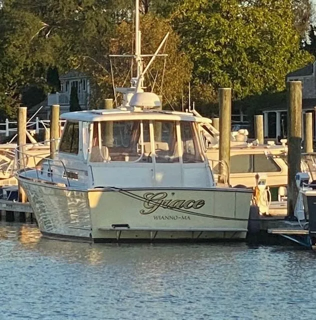 Slide: The Image of 2004 Sabre 42 Express Hardtop boat docked in a marina, surrounded by trees. - 10