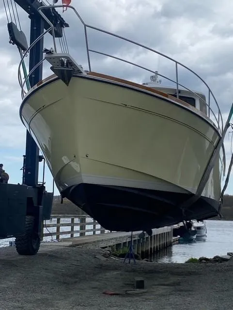 Slide: The Image of 2004 Sabre 42 Express Hardtop boat being lifted from the water. - 13