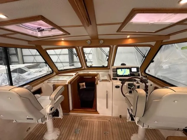 Slide: The Image of 2004 Sabre 42 Express Hardtop interior with helm, seating, and navigation equipment. - 23