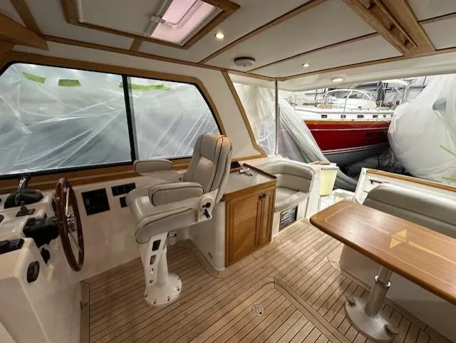 Slide: The Image of Interior of 2004 Sabre 42 Express Hardtop with helm, seating, and wooden flooring. - 27