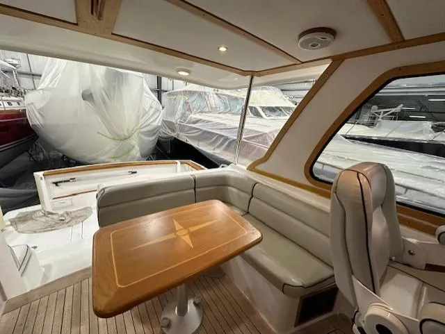 Slide: The Image of 2004 Sabre 42 Express Hardtop interior with wooden table and cushioned seating. - 29