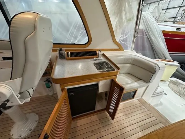 Slide: The Image of 2004 Sabre 42 Express Hardtop interior with seating, kitchenette, and wooden flooring. - 30