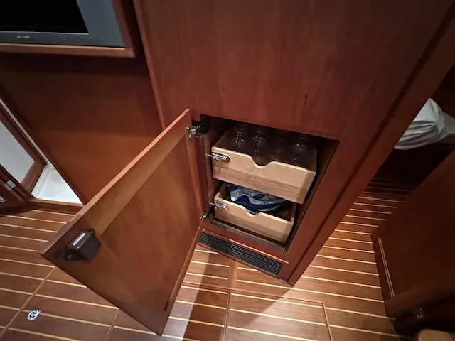 Slide: The Image of Wooden cabinet with open door, revealing storage drawers in 2004 Sabre 42 Express Hardtop. - 40