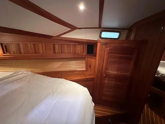 Slide: The Image of 2004 Sabre 42 Express Hardtop cabin with wooden interior and cozy bed. - 42