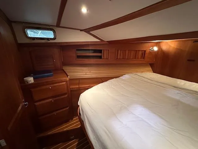 Slide: The Image of 2004 Sabre 42 Express Hardtop cabin with wooden interior and cozy bed. - 43