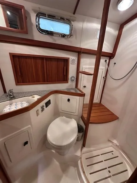 Slide: The Image of 2004 Sabre 42 Express Hardtop yacht bathroom with shower, sink, and wooden accents. - 45