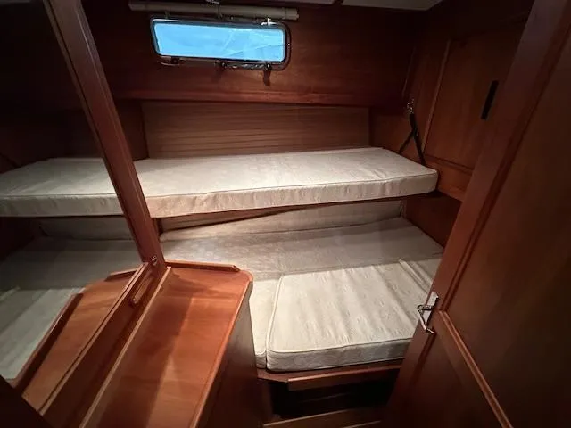 Slide: The Image of 2004 Sabre 42 Express Hardtop cabin with wooden interior and bunk beds. - 49