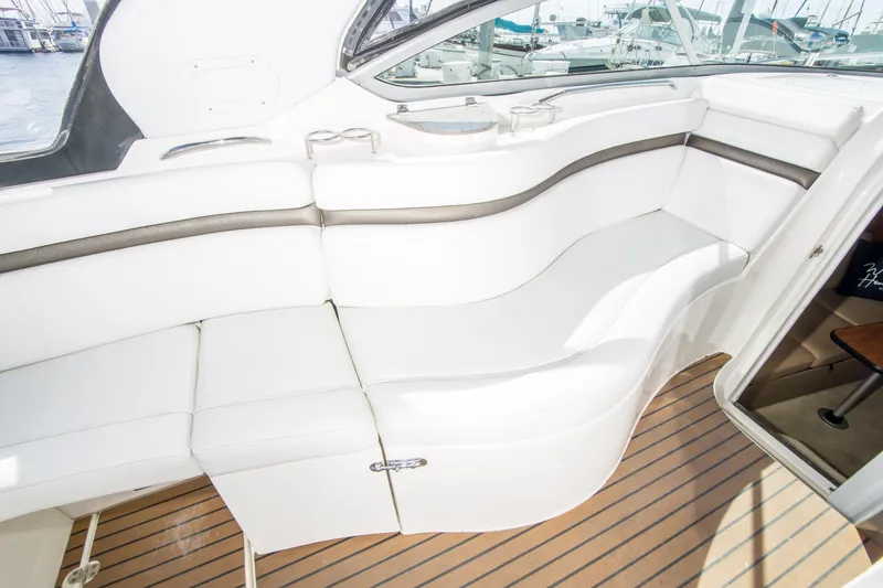 Slide: The Image of 2012 Rinker 310 Express Cruiser interior with white seating and wood flooring. - 10