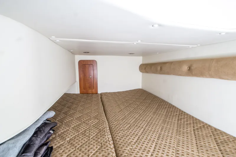 Slide: The Image of Interior cabin of 2012 Rinker 310 Express Cruiser with cozy bedding and wooden door. - 19