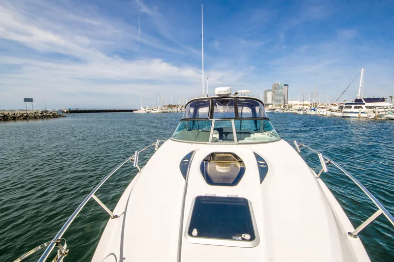 Slide: The Image of 2012 Rinker 310 Express Cruiser on water, marina background, clear sky. - 6