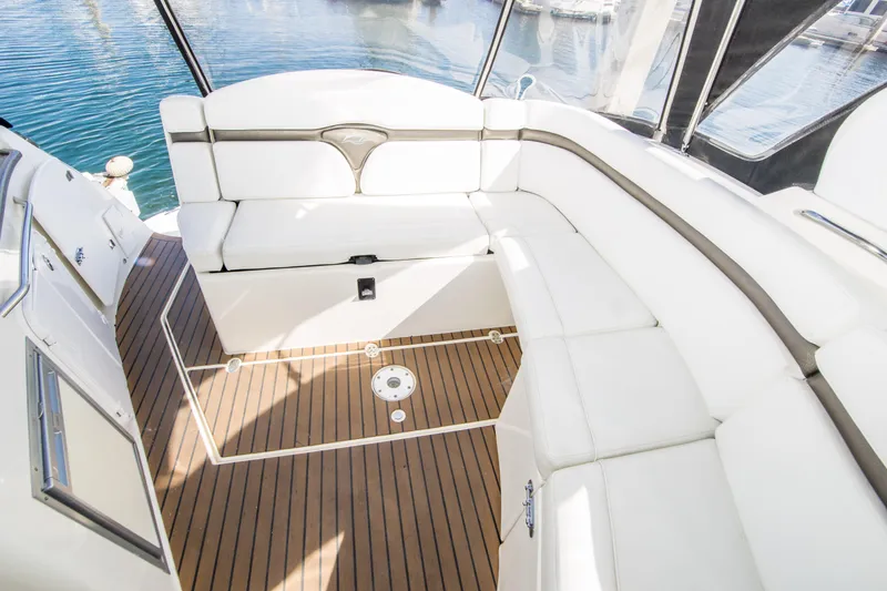 Slide: The Image of 2012 Rinker 310 Express Cruiser interior with white seating and teak flooring. - 8